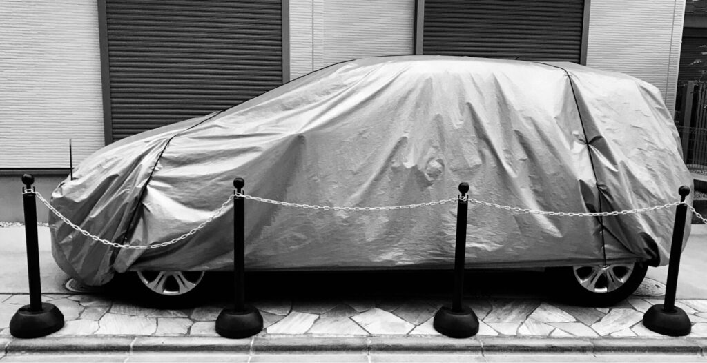 ボディカバーを装着した車が駐車場に止まっている