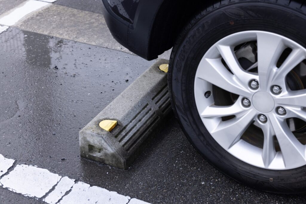 駐車場の車止めに当たったアルミホイール