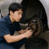 ドラムブレーキを修理する男