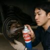 パーツクリーナーをブレーキに吹きかけて整備する男