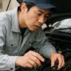 ラジエーターキャップを開けて中を確認する整備士