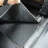 運転席のフロアマットをめくって確認している