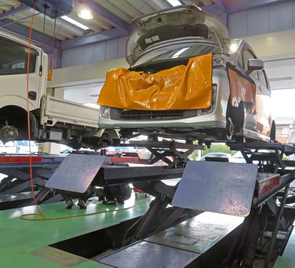 整備工場で車をリフトアップして点検する