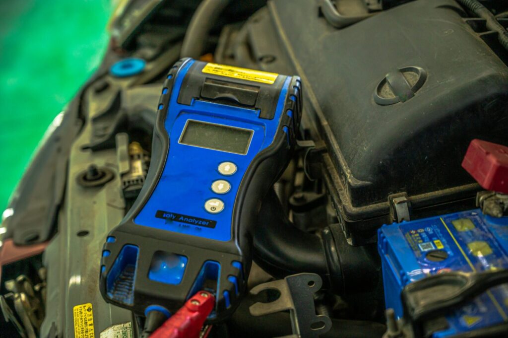 弱ったバッテリーに充電器をつないで充電している