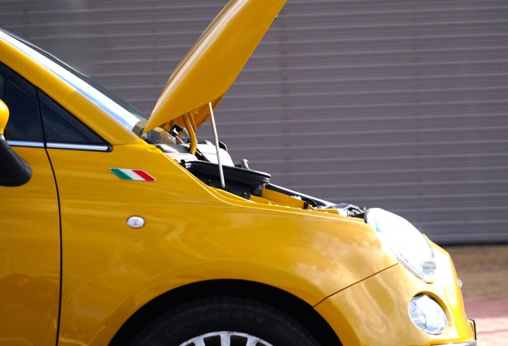 ボンネットを開けて整備中の中古車