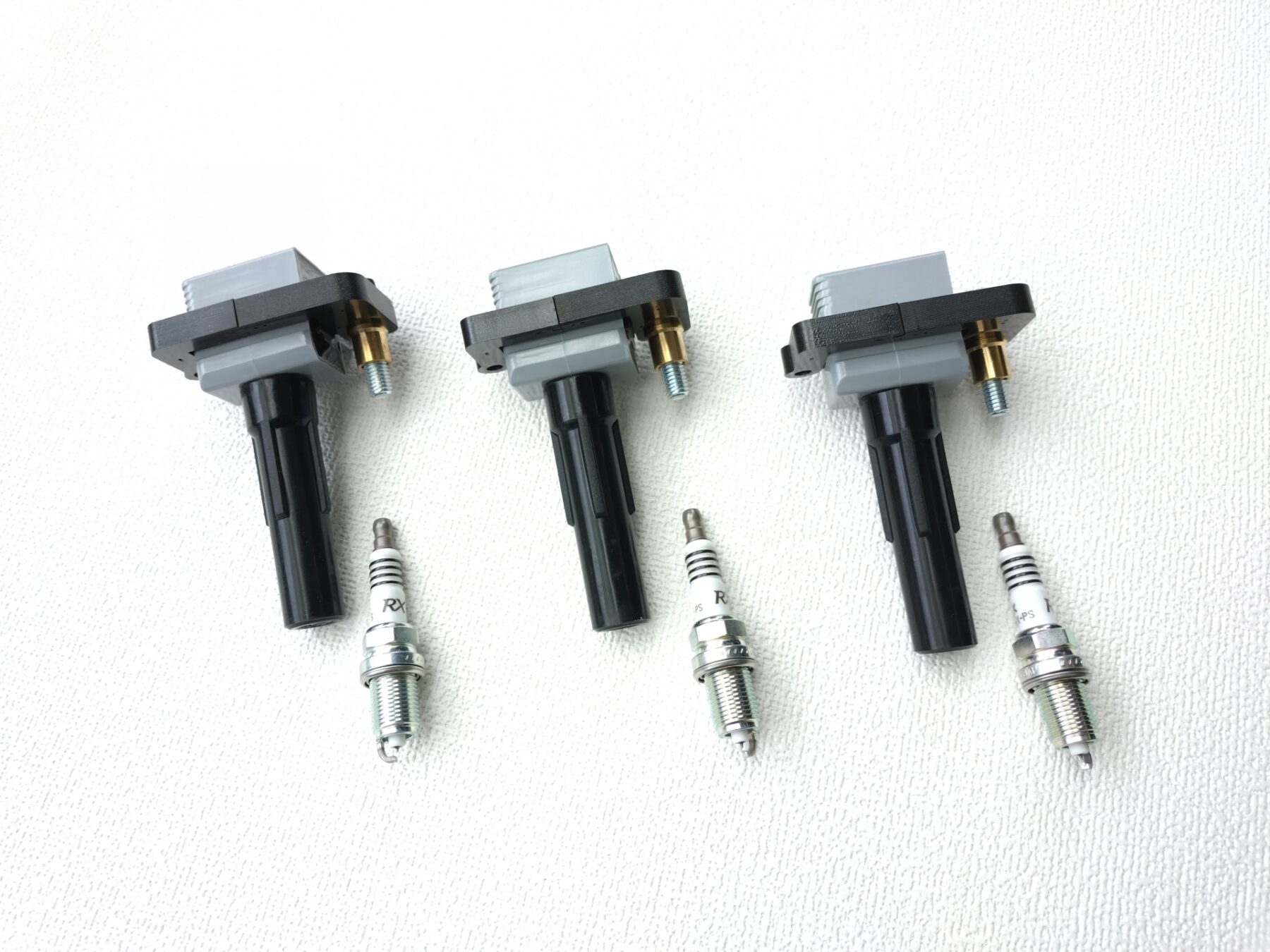 新品のイグニッションコイルとプラグ