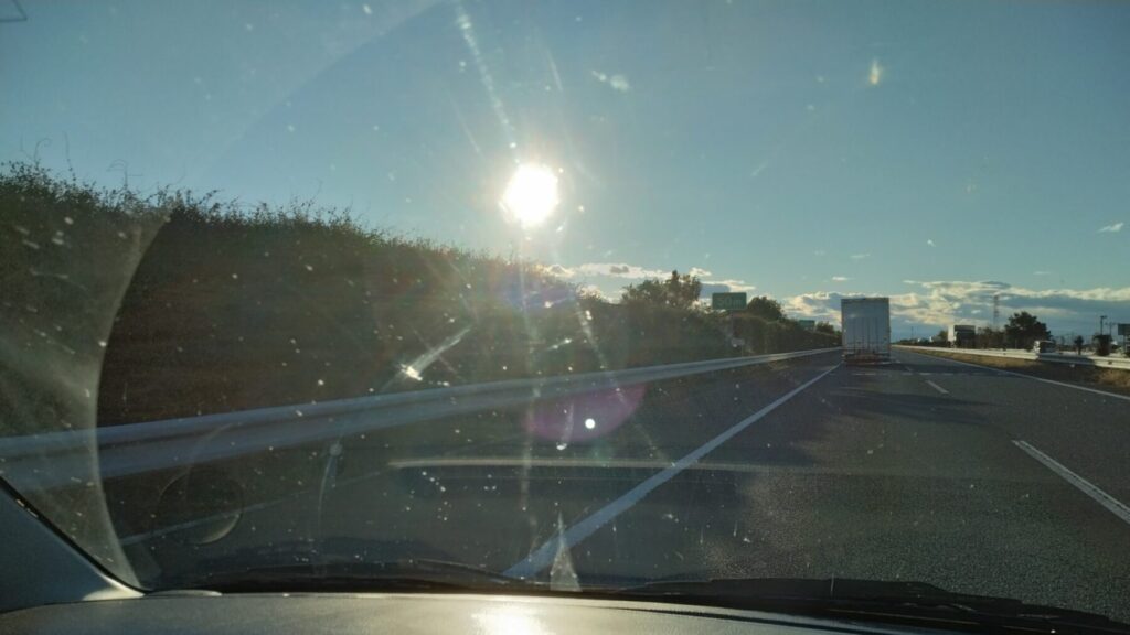 高速を走る車のフロントガラスに虫がぶつかり汚れている