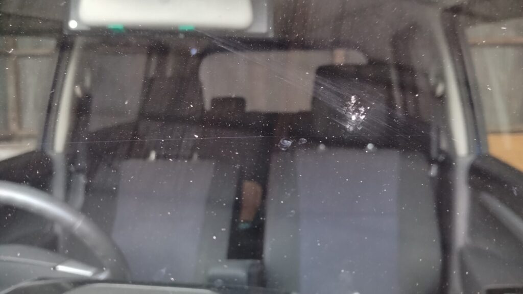 車のフロントガラスが虫のぶつかった跡で白く汚れている