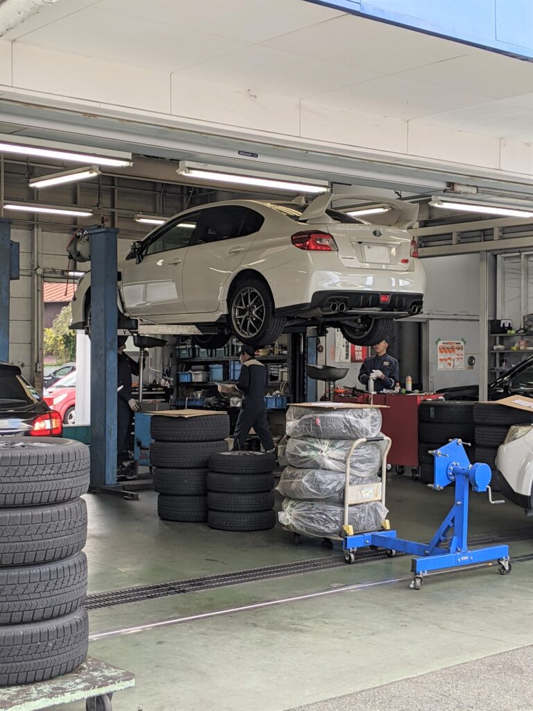 車をジャッキアップして下回りを点検している