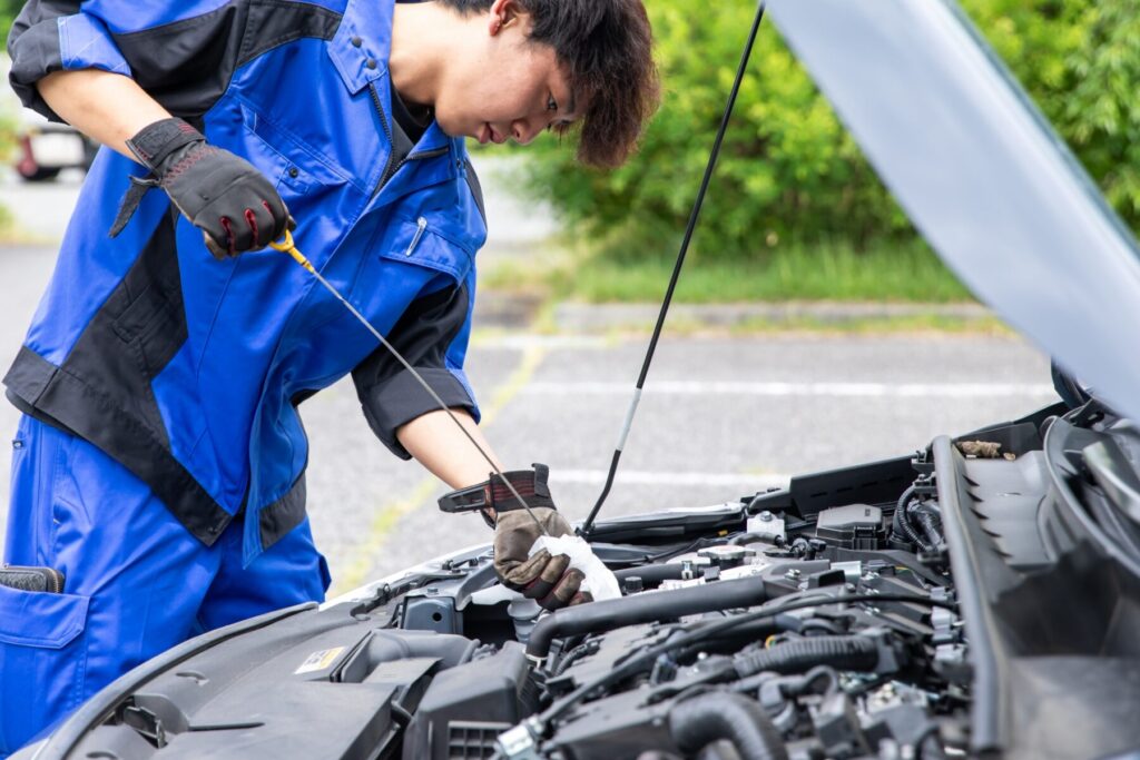 エンジンのレベルゲージを確認する整備士