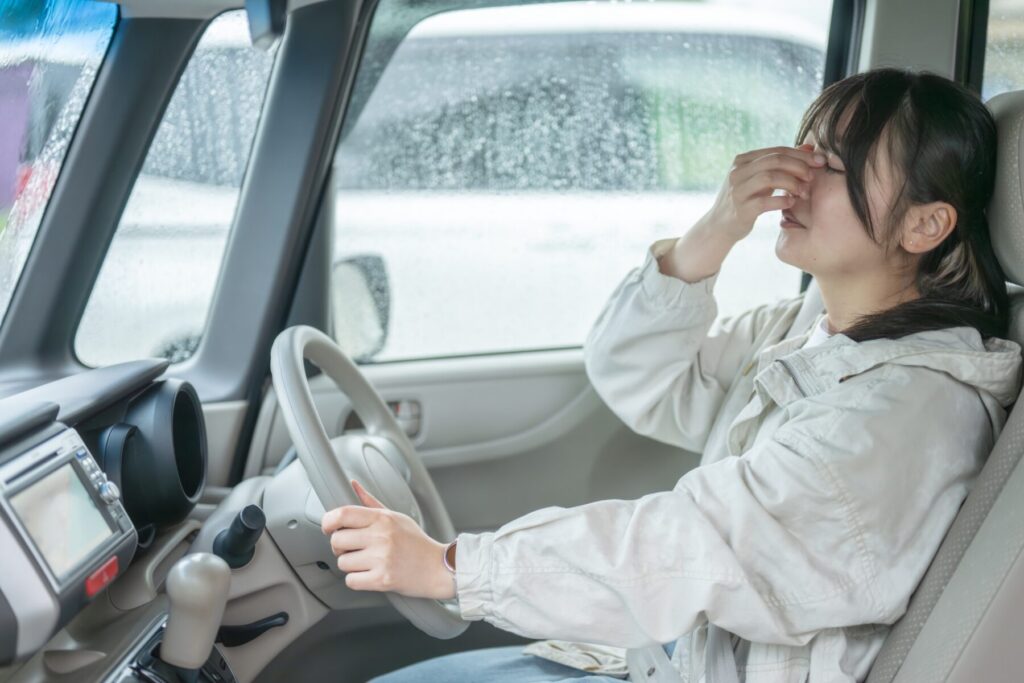 運転に疲れ目頭をマッサージする女