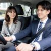 運転席に座る会社員の男と助手席に座る会社員の女