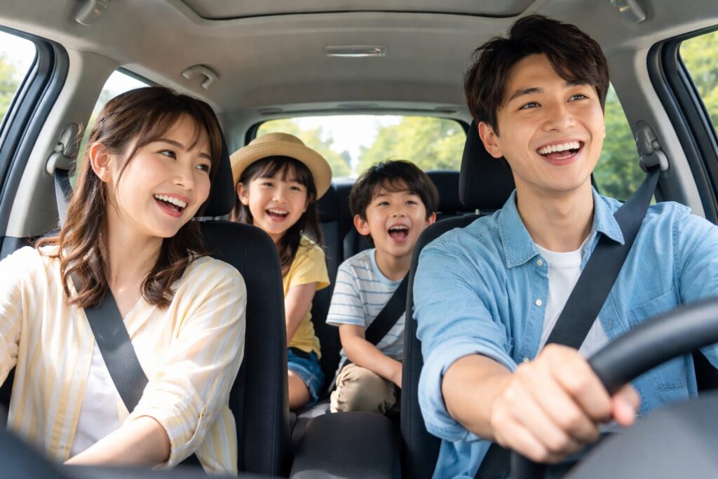 ドライブを楽しむ軽自動車車内の4人家族